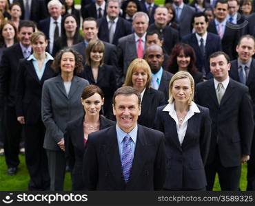 Large group of business people standing on lawn, portrait, elevated view