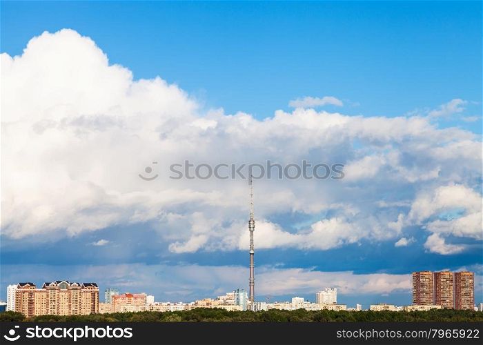 large low white cloud in blue sky over city with TV tower in summer day