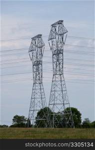 Large metal electricity pylons march across the countryside