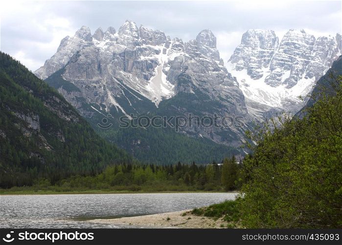 large mountain lake with snowed mountains in the background, italy dolomites