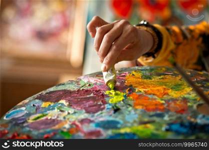 Large palette with a variety of colors.. The artist mixes oil paints on the palette 2898.