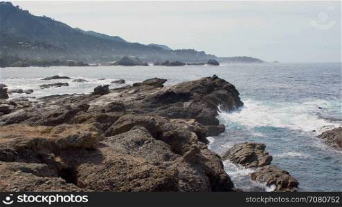 Large rugged rocks along the coast of California Big Sur