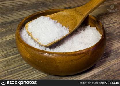 Large sea salt on wooden background