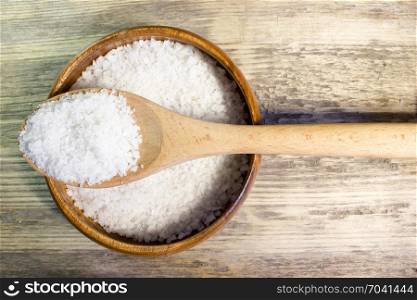 Large sea salt on wooden background