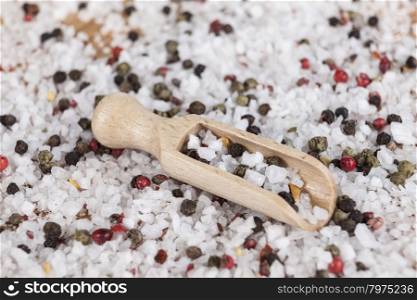 Large sea salt with red and black pepper. Large sea salt with red and black pepper with a small wooden spoons on a beautiful wooden tray .