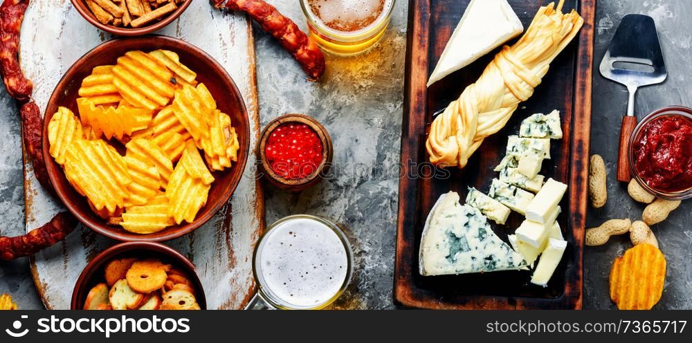 Large selection of snacks for beer. Set of cheeses, fish, chips and snacks. Snacks for beer