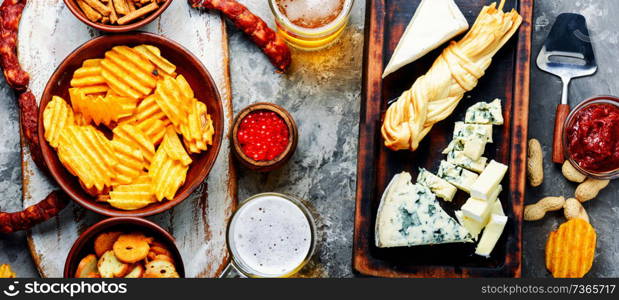 Large selection of snacks for beer. Set of cheeses, fish, chips and snacks. Snacks for beer