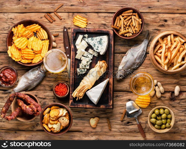 Large selection of snacks for beer. Set of cheeses, fish, chips and snacks.Selection food. Lager beer and snacks