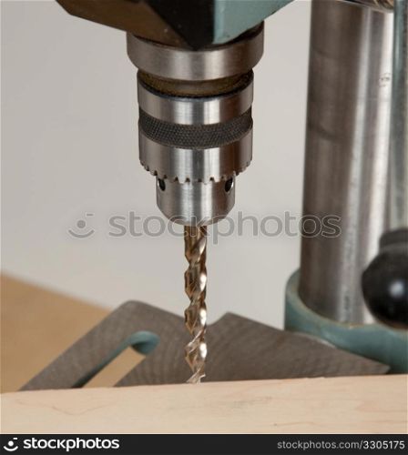 Large sized drill in solid chuck about to drill wood