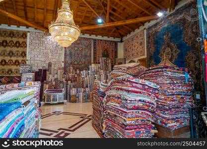 Large stacks of oriental rugs in a store. Colorful carpet market. Turkey