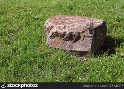 Large stone slab among the green grass