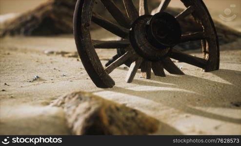 Large wooden wheel in the sand