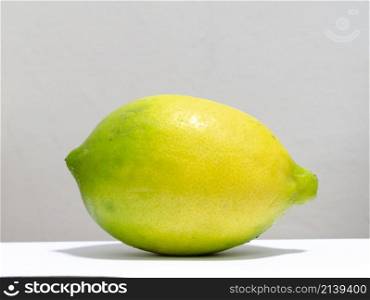 large yellow and green lemon in front of a white background