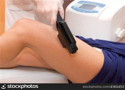 Laser epilation of leg in a modern beauty shop