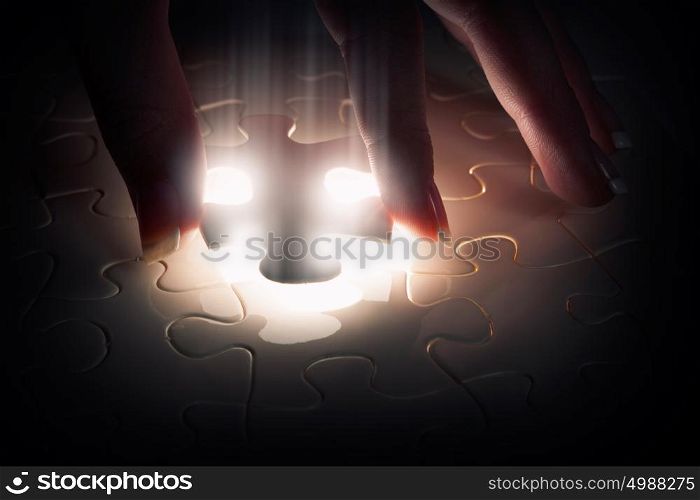 Last element of jigsaw. Hand connecting missing jigsaw glowing puzzle piece
