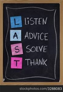 LAST (listen, advice, solve, thank) - acronym for training customer service and complaints handling. blackboard with sticky notes and white chalk handwriting