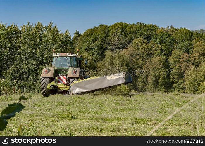 Last mowing of a tractor in a meadow of the gaume near Virton in Belgium