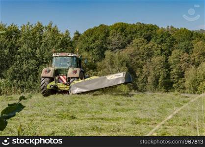 Last mowing of a tractor in a meadow of the gaume near Virton in Belgium