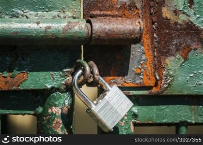 Latch on iron latticework door with locked padlock