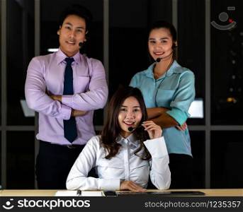Late Night Environment, Potrait of friendly Call centre operator team with headsets in a call center customer service and technical support. Using for 24 Hr. Call center Concept.
