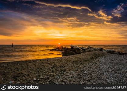 Late summer dawn on a pebble beach with rocks