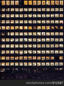 Late Working urban concept, window facade of business center office building at night, New York city NY USA