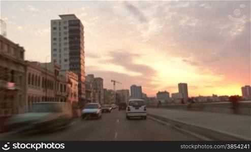 Latin American cities and travel, time-lapse of the city of La Habana, Cuba at sunset with cars on the road, people and street traffic