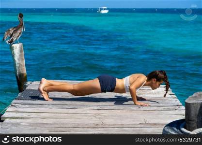 Latin athlete woman push up workout in Caribbean beach pier