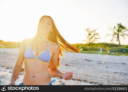 Latin beautiful bikini girl happy in Caribbean beach sunset