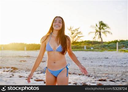 Latin beautiful bikini girl happy in Caribbean beach sunset