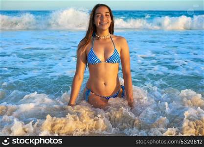 Latin beautiful bikini girl happy sitting in Caribbean beach sunset