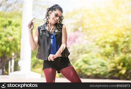 Latin girl listening to music outside, Urban girl enjoying music with headphones, Happy woman listening to music outside