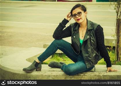 Latin girl with sitting on a bench, attractive girl with glasses sitting on a bench