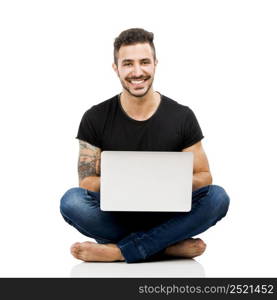 Latin man sitting on the floor and working with a laptop