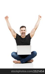 Latin man sitting on the floor and working with a laptop with both arms up