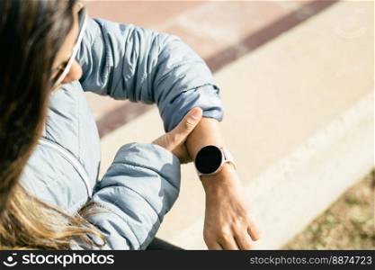 latin woman looking at heart rate on smart watch