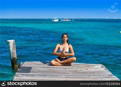 Latin woman yoga relaxing in Caribbean beach pier