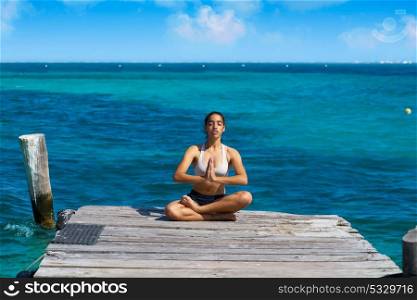 Latin woman yoga relaxing in Caribbean beach pier