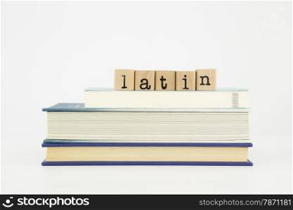 latin word on wood stamps stack on books, language and study concept