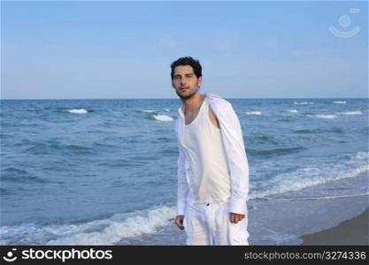 Latin young man white shirt walking on blue beach outdoor