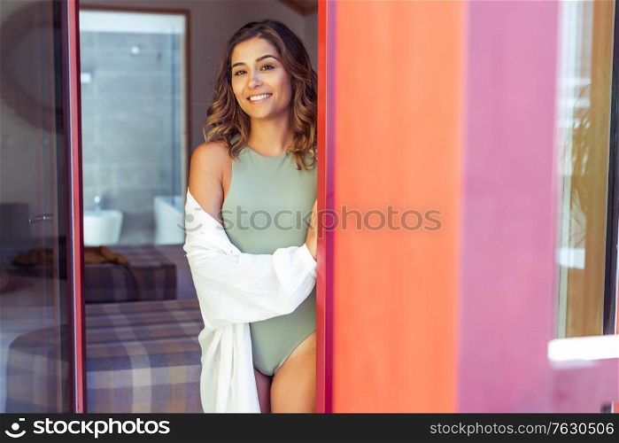 Latin young woman enjoying the sun through the window