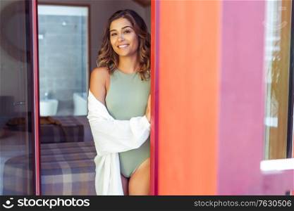 Latin young woman enjoying the sun through the window