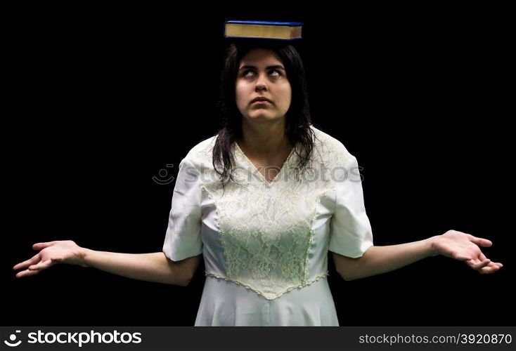Latina teenager in white dress standing in front of black background balancing book on her head and rolling her eyes