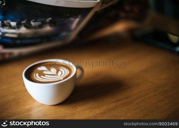 Latte art in coffee cup on the cafe table