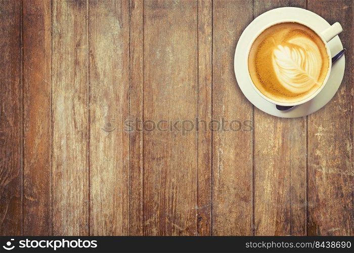 Latte coffee cup on wood table background with space.