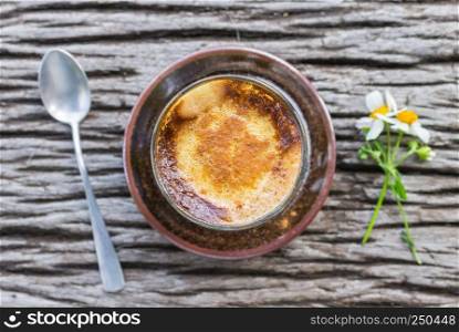 Latte Coffee in Glass with Daisy Flower and Spoon on Wood Table Flatray or Top Table Angle. Classic coffee with flower in natural life concept. Relax coffee break time background in coffee shop