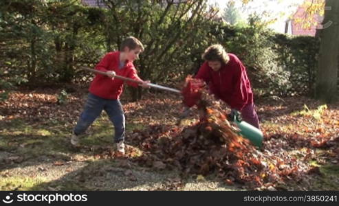 Laubrechen im Garten (Mutter und Kinder)