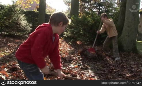 Laubrechen im Garten (Mutter und Kinder)