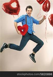 Laughing and jumping guy with valentine&rsquo;s balloons