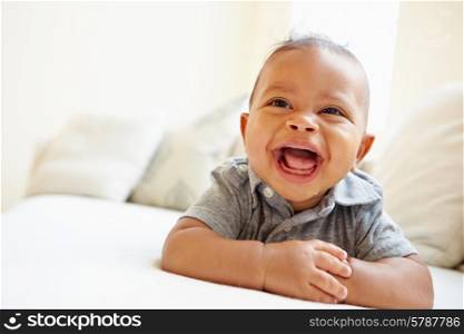 Laughing Baby Boy Lying On Tummy At Home